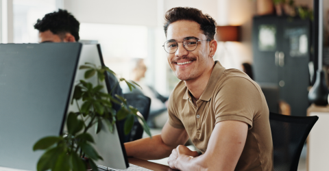 Een glimlachende man werkt op een computer
