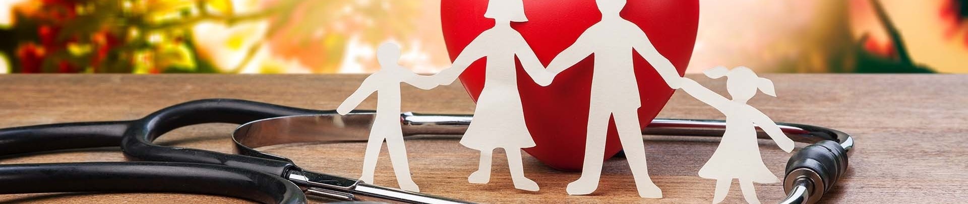 Gezondheid silhouetten van een gezin hand in hand met een stethoscoop en een rood hart